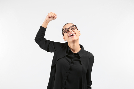 Happy successful young woman on light backgroundの写真素材