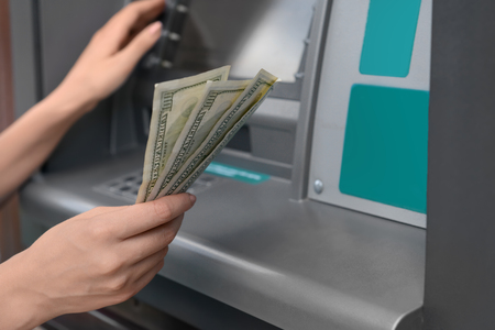 Woman with dollar banknotes near cash machine, closeupの写真素材
