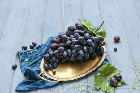 Tray with fresh ripe grapes on wooden tableの写真素材