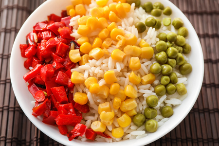 Plate with tasty boiled rice and vegetables on bamboo matの写真素材