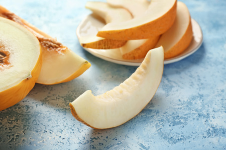 Cut ripe melon on color tableの写真素材