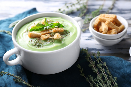 Pot with delicious zucchini soup and croutons on tableの写真素材