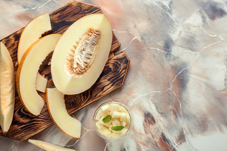 Cut ripe melon on color tableの写真素材