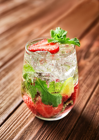 Glass of fresh strawberry mojito on wooden tableの写真素材