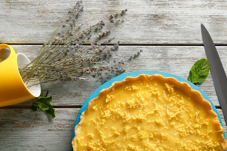 Board with delicious lemon pie and lavender on wooden tableの写真素材
