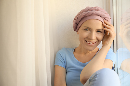 Woman after chemotherapy near window at homeの写真素材