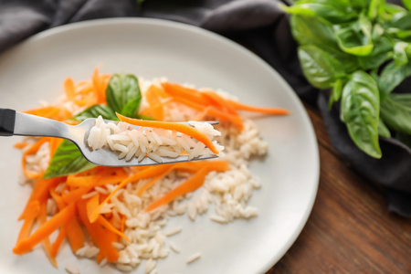 Eating of boiled rice with carrot, closeupの写真素材