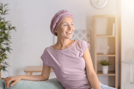 Happy woman after chemotherapy  sitting on sofa at homeの写真素材