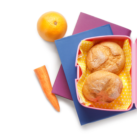Food for schoolchild in lunch box and books on white backgroundの写真素材