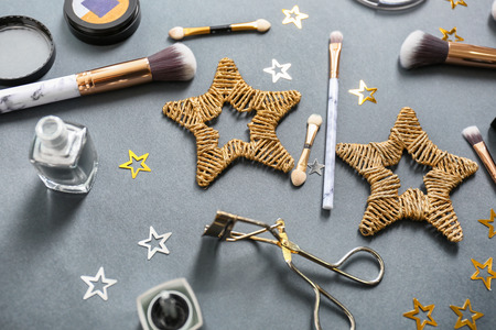 Set of cosmetics with decorations on grey background