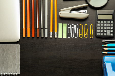Composition with different school stationery on dark background