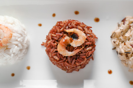 Different boiled rice with shrimps on plate, closeupの写真素材