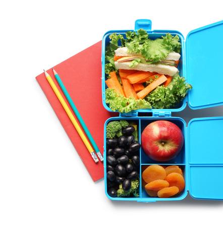 Food for schoolchild in lunch boxes and stationery on white backgroundの写真素材