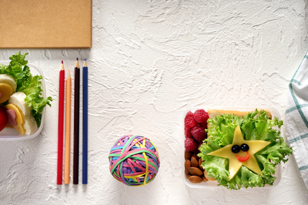 Composition with appetizing food for schoolchild and stationery on light backgroundの写真素材
