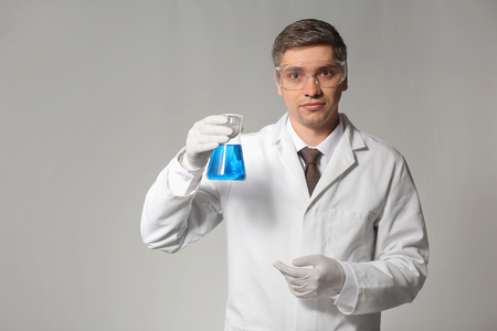 Scientist with test sample on grey backgroundの写真素材