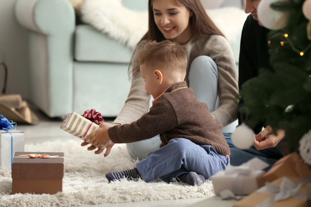 Happy family with Christmas gifts at homeの写真素材