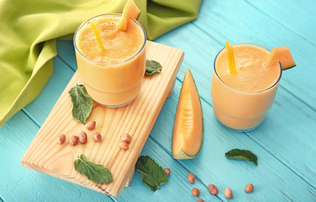 Glasses with tasty melon smoothie on blue tableの写真素材