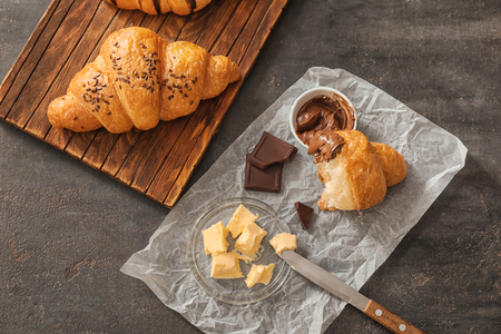 Tasty croissants with chocolate and butter on dark tableの写真素材