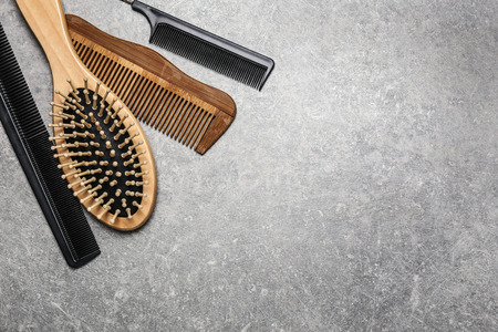Hair brush with combs on grey background