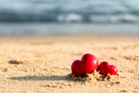 Small red hearts on beach sandの写真素材