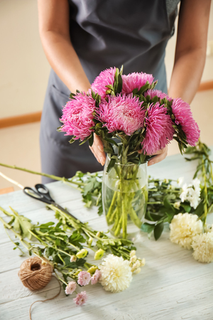 Florist making bouquet of beautiful  chrysanthemum flowers at tableの写真素材