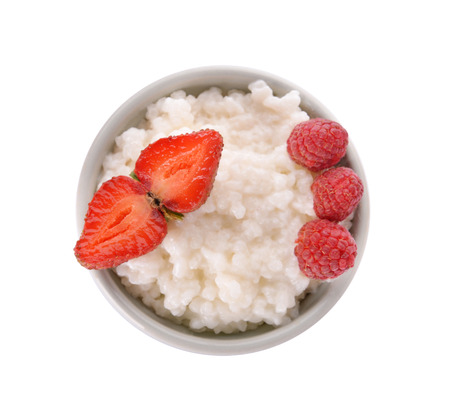 Delicious rice pudding with berries in bowl on white backgroundの写真素材