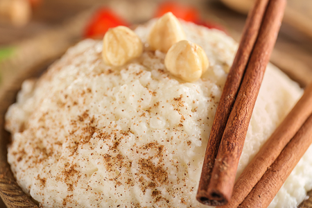 Delicious rice pudding with cinnamon and hazelnuts in bowl, closeupの写真素材