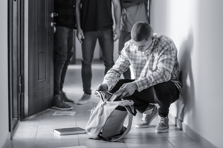 Aggressive teenagers bullying boy at schoolの写真素材