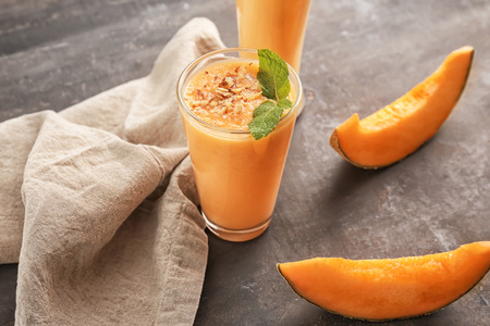 Glass of tasty melon smoothie on tableの写真素材