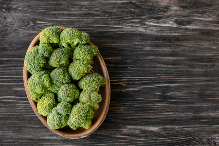 Bowl with fresh green broccoli on wooden tableの写真素材