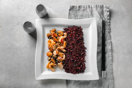 Plate with tasty boiled rice and seafood on light backgroundの写真素材