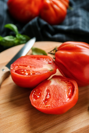 Delicious sliced tomatoes on wooden board, closeupの写真素材