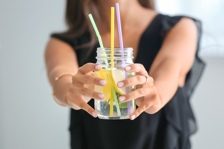 Young woman with mason jar of fresh lemonade, closeupの写真素材