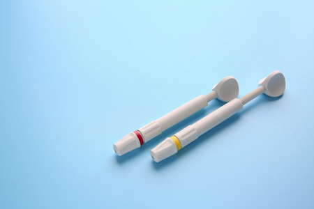 Syringes of resin luting cement on color backgroundの写真素材
