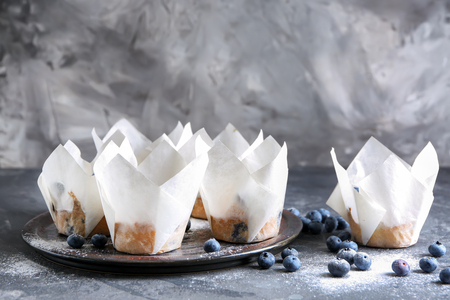 Tray with tasty blueberry muffins on grey tableの写真素材