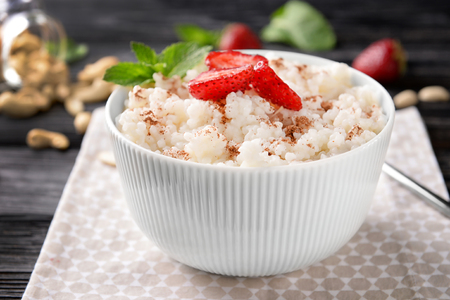 Bowl with delicious rice pudding and strawberry on napkinの写真素材