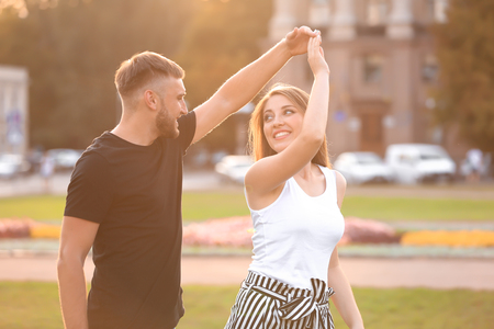 Happy young couple dancing outdoorsの写真素材