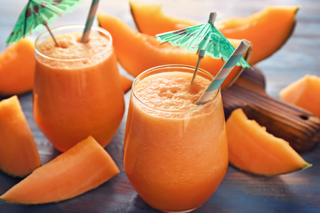 Glasses of tasty melon smoothie on wooden tableの写真素材