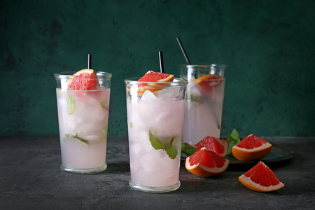 Glasses of refreshing grapefruit lemonade on tableの写真素材