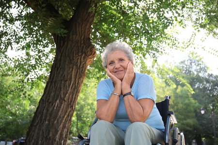 Senior woman in wheelchair outdoorsの写真素材