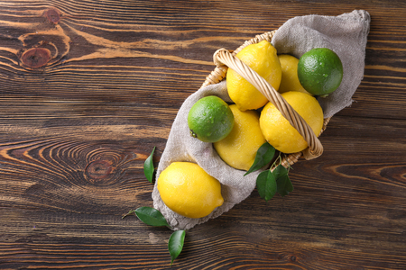 Wicker basket with ripe lemons on wooden tableの写真素材