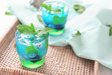Glasses of refreshing summer cocktail on wicker trayの写真素材