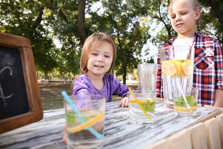 Little girls selling lemonade at counter in parkの写真素材