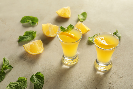 Glasses of fresh lemon cocktail on grey backgroundの写真素材