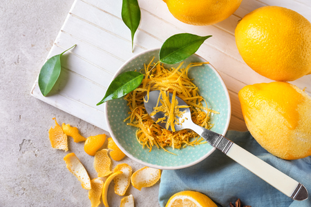 Ripe lemons with zest on wooden boardの写真素材