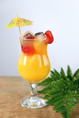 Fresh summer cocktail in glass on wooden table against light backgroundの写真素材