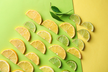 Composition with slices of ripe lemon and lime on color backgroundの写真素材