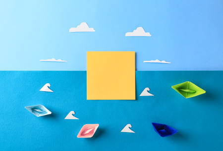 Composition with origami boats on color background