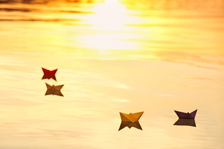 Origami boats on water surface at sunsetの写真素材