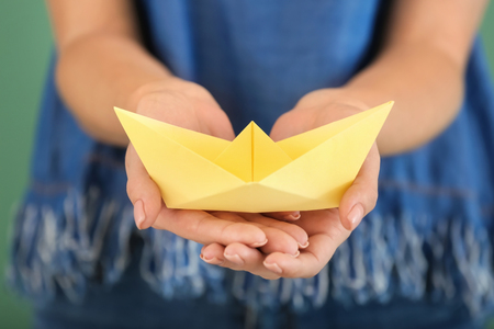 Woman holding origami boat, closeupの写真素材